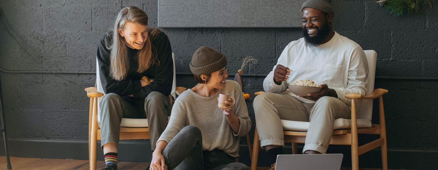 friends sit together around an open laptop